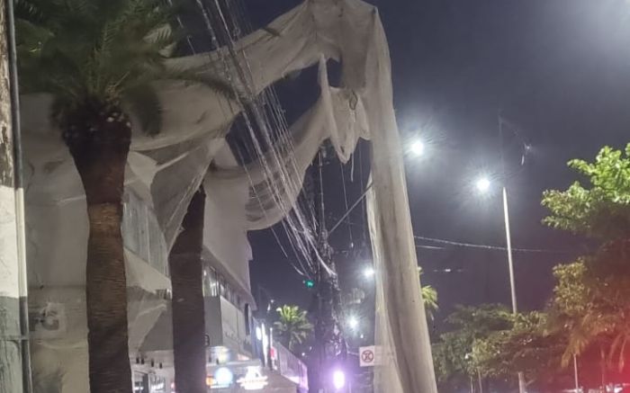 Tela de proteção de prédio caiu na rede elétrica de BC (Foto: Leitor)