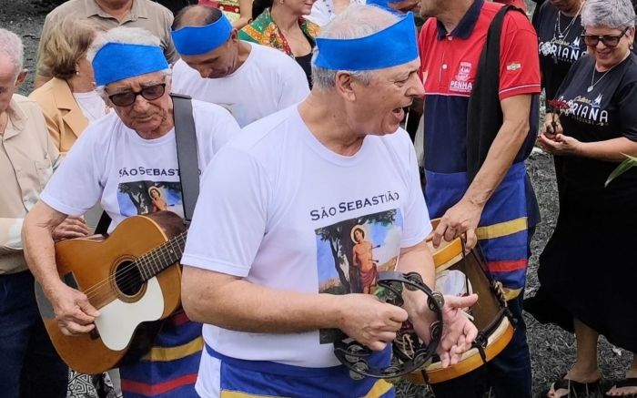 Legenda: Enquanto promesseiros cantam, as mulheres devotas prendem ramos verdes e flores no mastro, decorando-o (Fotos Arquivo )