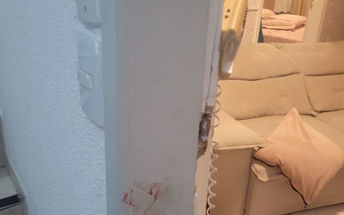 Mulher conseguiu se trancar num quarto antes da chegada da PM (Foto: PMSC)