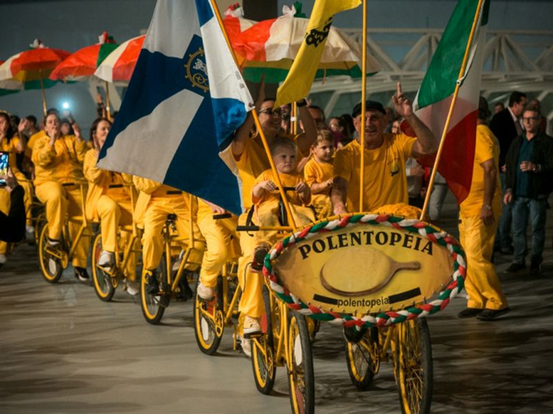 Polentopéia - Uma bicicleta gigante equipada com uma grande panela, botijão de gás e várias linguiças penduradas foi uma das atrações da sessão especial que celebrou os 150 anos da imigração italiana em Santa Catarina, na Alesc. A Polentopeia de 24 metros e 17 carrinhos carregando 34 pessoas, incluindo um DJ e o cozinheiro, chamou a atenção no Palácio Barriga Verde.  (Divulgação/Alesc)